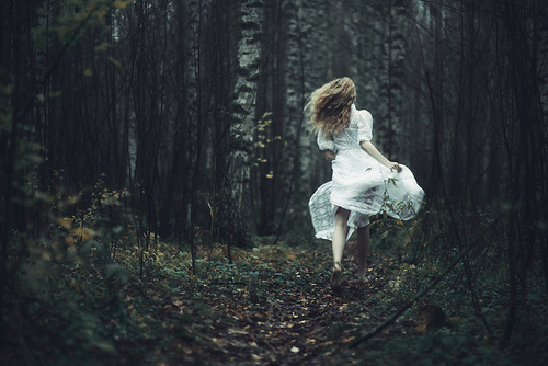 girl-running-through-a-wood-in-a-white-dress